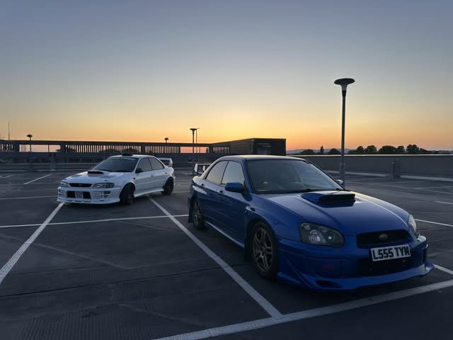 Two Subaru cars at sunset